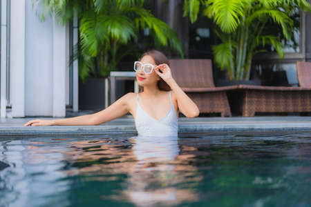 Portrait beautiful young asian woman relax smile leisure around outdoor swimming pool in hotel resortの写真素材