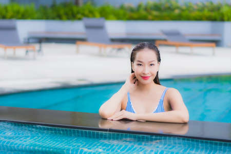 Portrait beautiful young asian woman relax smile leisure around outdoor swimming pool in hotel resortの写真素材
