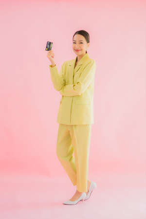 Portrait beautiful young asian business woman smile in action on pink color backgroundの写真素材