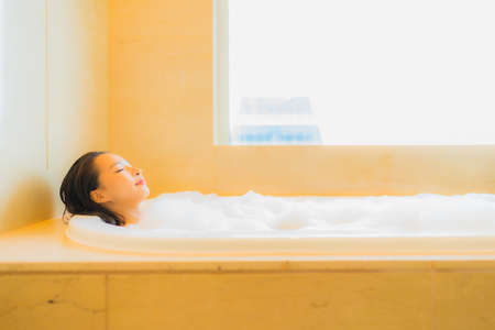 Portrait beautiful young asian woman relax smile leisure in bathtub at bathroom interiorの写真素材