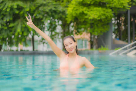 Portrait beautiful young asian woman relax smile leisure around outdoor swimming pool in hotel resortの写真素材