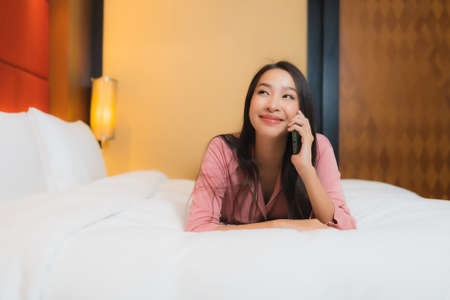 Portrait beautiful young asian woman relax smile happy on sofa decoration interior of bedroomの写真素材