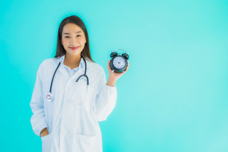 Portrait beautiful young asian woman thai nurse smile happy ready for work for patient in clinic or hospital on yellow isolated backgroundの写真素材