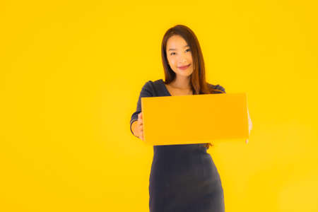 Portrait beautiful young asian woman with colorful shopping bag on yellow isolated background