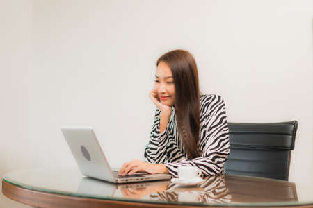 Portrait beautiful young asian woman use computer laptop on working table in room