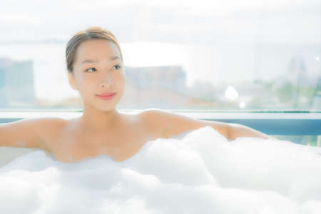 Portrait beautiful young asian woman relax enjoy in bathtub in bathroom interiorの写真素材