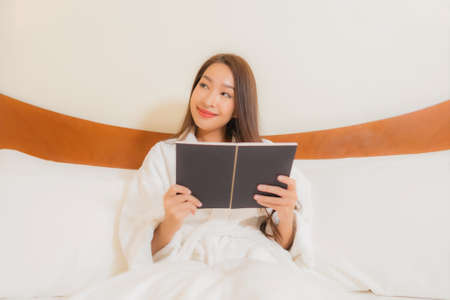 Portrait beautiful young asian woman smile relax leisure on bed in bedroom interiorの写真素材