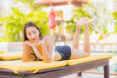 Portrait beautiful young asian woman relax smile around outdoor swimming pool in hotel resortの写真素材