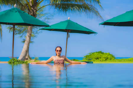 Portrait beautiful young asian woman smile relax leisure around outdoor swimming pool in hotel...