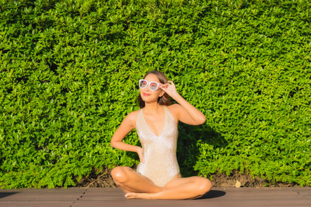 Portrait beautiful young asian woman smile relax leisure around outdoor swimming pool with city viewの写真素材