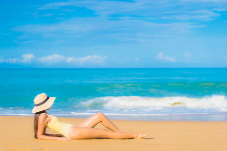 Portrait beautiful young asian woman relax leisure smile around beach sea ocean at sunset timeの写真素材