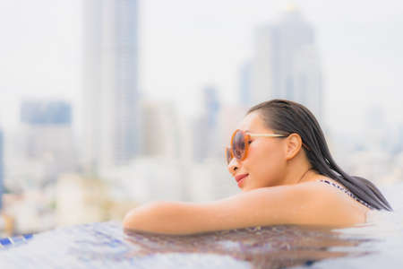 Portrait beautiful young asian woman relax smile leisure around outdoor swimming pool nearly sea beach in Travel vacationの写真素材