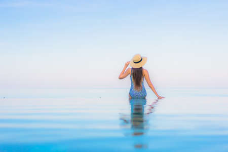 Portrait beautiful young asian woman relax smile leisure around outdoor swimming pool nearly sea beach in Travel vacationの写真素材