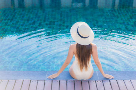 Portrait beautiful young asian woman smile relax leisure around outdoor swimming pool with city view