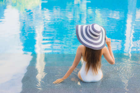 Portrait beautiful young asian woman relax smile around outdoor swimming pool in hotel resort for travel vacationの写真素材