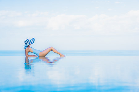 Portrait beautiful young asian woman relax smile around outdoor swimming pool in hotel resort nearly sea beach oceanの写真素材