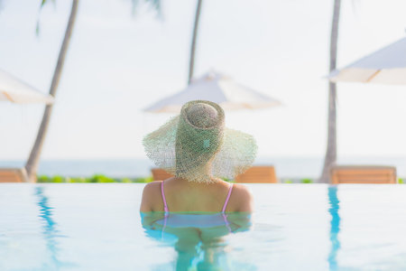 Portrait beautiful young asian woman relax leisure around outdoor swimming pool with sea beach ocean view in vacation travelの写真素材
