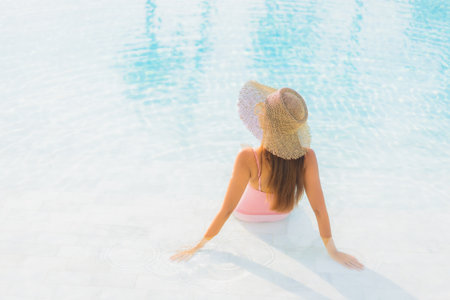 Portrait beautiful young asian woman relax leisure around outdoor swimming pool with sea beach ocean view in vacation travelの写真素材