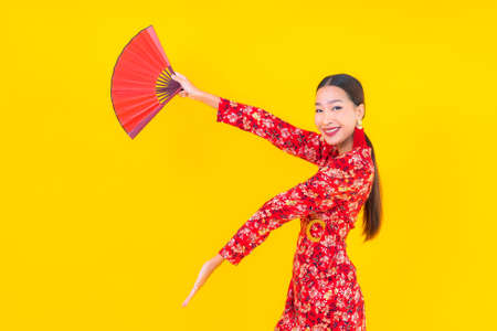 Portrait beautiful young asian woman smile in action in chinese new year concept on color backgroundの写真素材