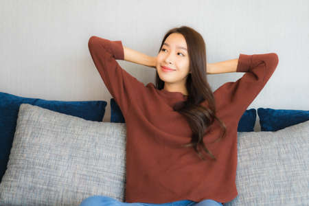 Portrait beautiful young asian woman hold coffee cup on sofa chair in living room area