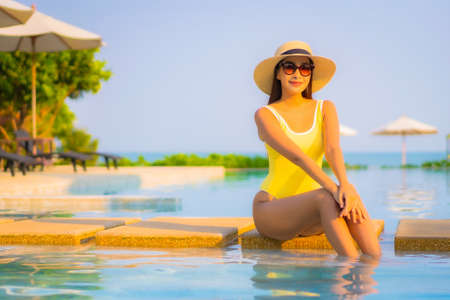 Portrait beautiful young asian woman relax smile enjoy leisure around swimming pool in resort hotel on vacationの写真素材