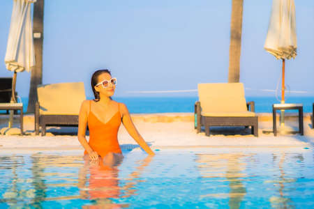 Portrait beautiful young asian woman relax smile enjoy leisure around swimming pool in resort hotel on vacationの写真素材