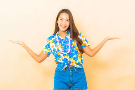 Portrait beautiful young asian woman wear colorful shirt for songkran festival on color backgroundの写真素材