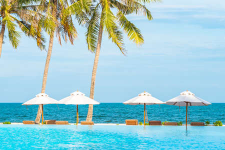 Portrait beautiful young business asian woman sit on chair with smile on red backgroundの写真素材