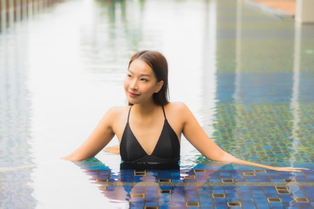 Portrait beautiful young asian woman relax smile leisure around outdoor swimming pool in hotel resortの写真素材