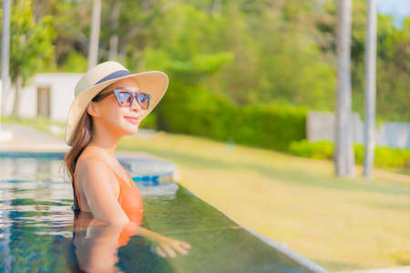 Portrait beautiful young asian woman relax smile leisure around outdoor swimming pool with sea ocean...