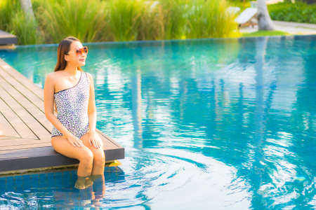 Portrait beautiful young asian woman happy smile relax around outdoor swimming pool in hotel resort for travel vacationの写真素材