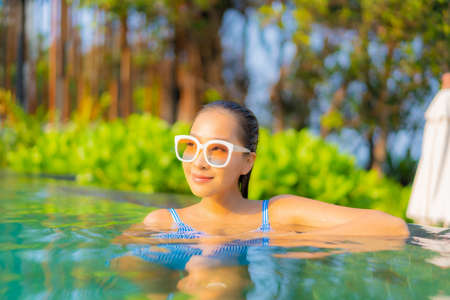 Portrait beautiful young asian woman happy smile relax around outdoor swimming pool in hotel resort for travel vacationの写真素材