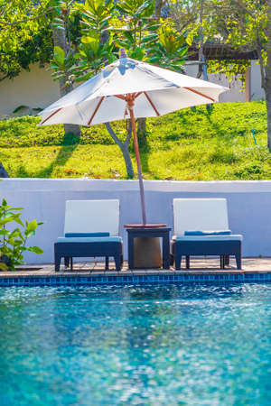 Umbrella and chair around outdoor swimming pool in hotel resort with sea ocean view for travel vacationの写真素材