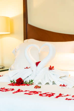 White Pillow and blanket with rose flower and swan towel on bed decoration interior of bedroomの写真素材