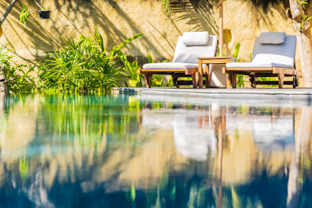 Umbrella and chair around outdoor swimming pool in resort hotel for vacation leisureの写真素材