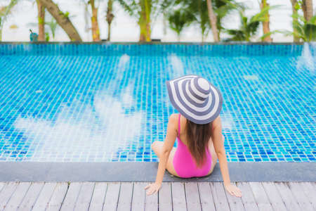 Portrait beautiful young asian woman relax smile enjoy leisure around swimming pool in resort hotel on vacationの写真素材