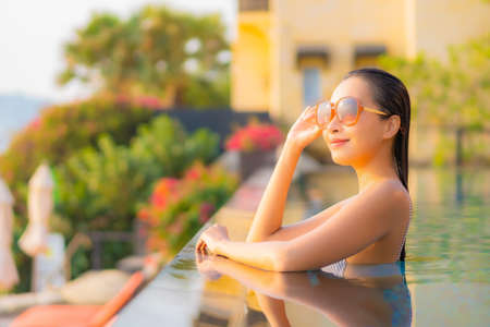 Portrait beautiful young asian woman relax smile leisure around sea beach ocean with white cloud on blue sky in travel vacationの写真素材