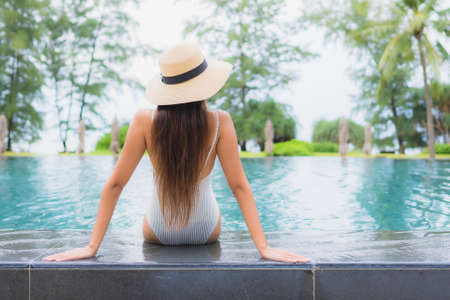 Portrait beautiful young asian woman relax smile leisure around outdoor swimming pool in resort hotel with sea ocean viewの写真素材