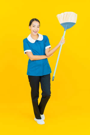 Portrait beautiful young asian woman wear red dress smile with action on yellow color backgroundの写真素材
