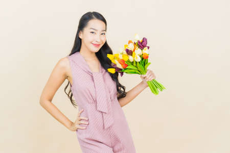 Portrait beautiful young asian woman smile with heart pillow shape on yellow color backgroundの写真素材