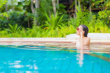 Portrait beautiful young asian woman relax around outdoor swimming pool in resort