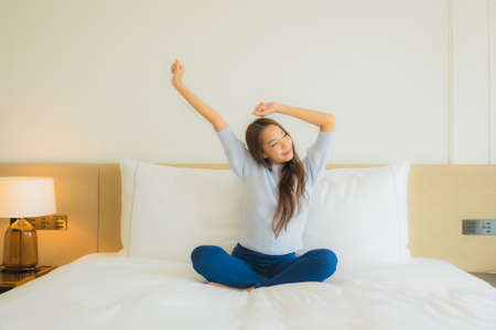 Portrait beautiful young asian woman relax smile in action on sofa in living room interiorの写真素材