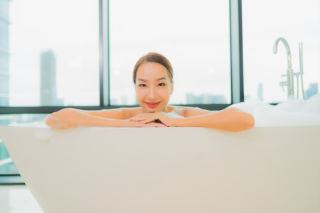 Portrait beautiful young asian woman relax smile leisure in bathtub in bathroom interiorの写真素材