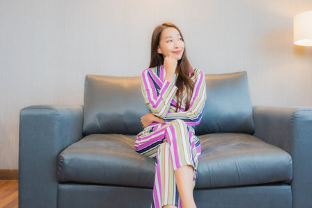 Portrait beautiful young asian woman relax on sofa in living room interior