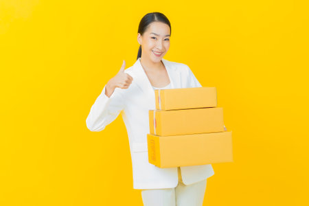 Portrait beautiful young asian woman with box ready for shipping on color backgroundの写真素材