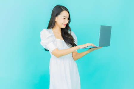 Portrait beautiful young asian woman smile with empty plate dish on color backgroundの写真素材
