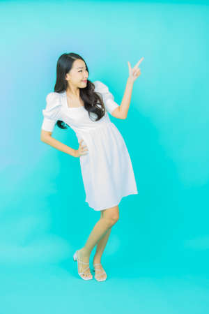 Portrait beautiful young asian woman smile with empty plate dish on color backgroundの写真素材