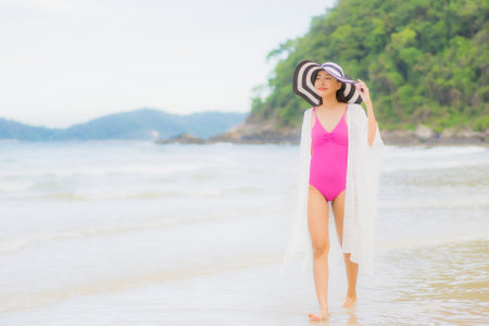 Portrait beautiful young asian woman use smart mobile phone on yellow color isolated backgroundの写真素材