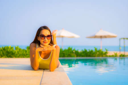 Portrait beautiful young asian woman relax smile enjoy leisure around swimming pool in resort hotel on vacationの写真素材