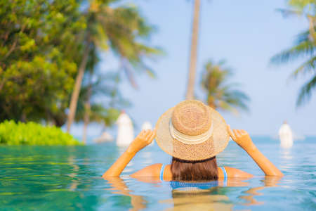Portrait beautiful young asian woman relax smile enjoy leisure around swimming pool nearly sea beach...